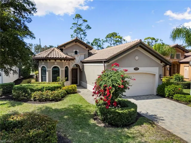 Mediterranean / spanish-style home featuring stucco siding, a garage, driveway, a tile roof, and a front lawn
