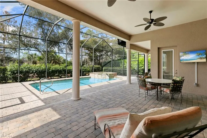 Combined pool / hot tub with a patio, outdoor dining space, a sunroom, and a lanai
