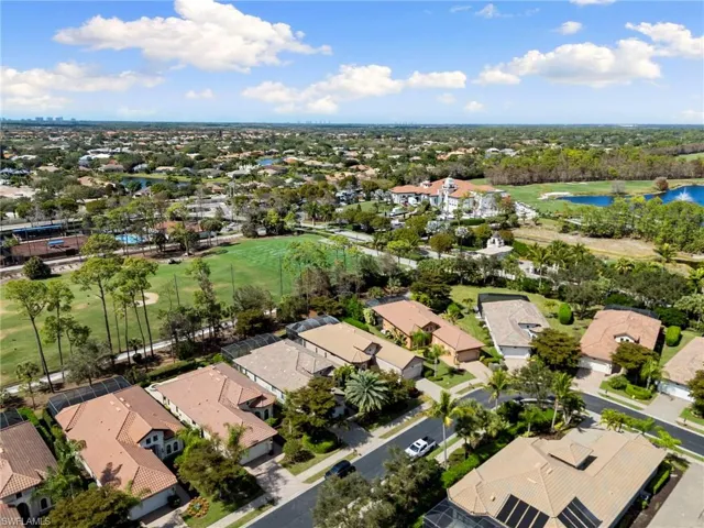 Aerial view of residential area featuring a local golf course and a large body of water