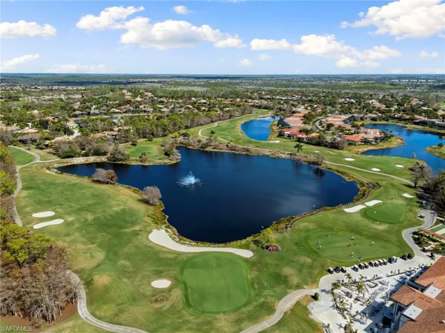 Aerial perspective of suburban area with a golf course and a large body of water