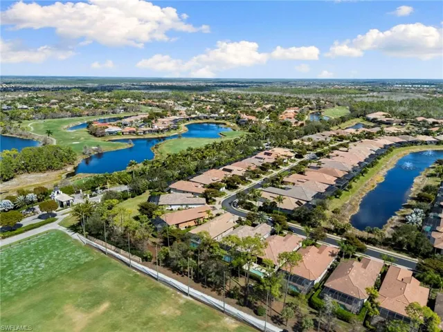 Aerial view of residential area with a nearby body of water and a golf course