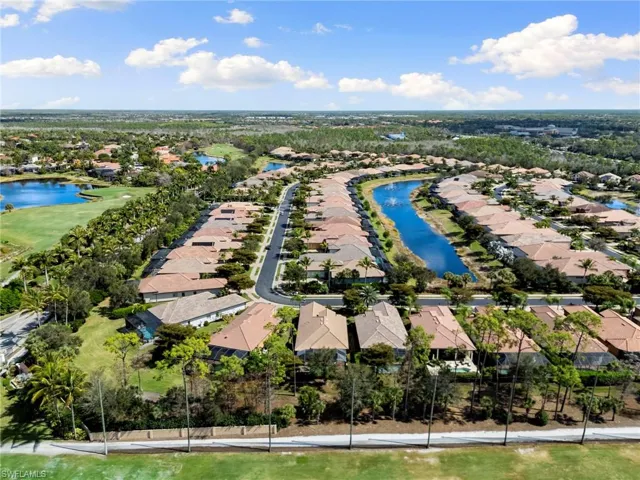 Aerial perspective of suburban area with a large body of water and a golf course