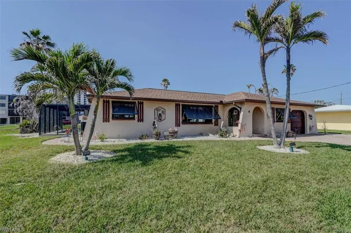 View of front of house with a garage and a front lawn