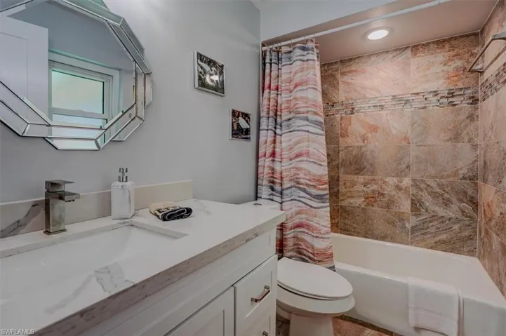 Full bathroom with vanity, toilet, and shower / bath combo with shower curtain