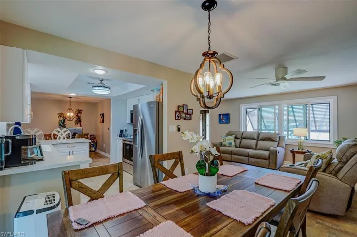 Dining space featuring ceiling fan with notable chandelier