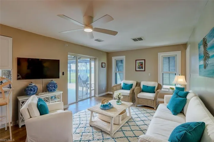 Living room with light hardwood / wood-style floors and ceiling fan
