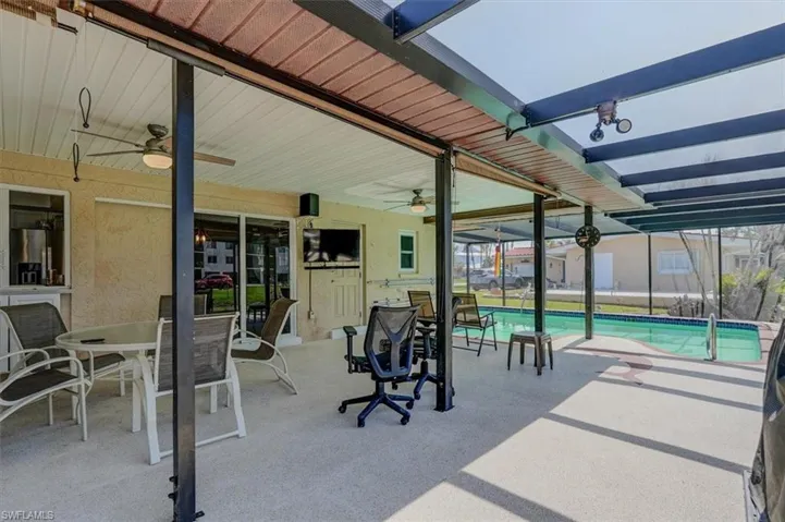 View of patio with ceiling fan and glass enclosure