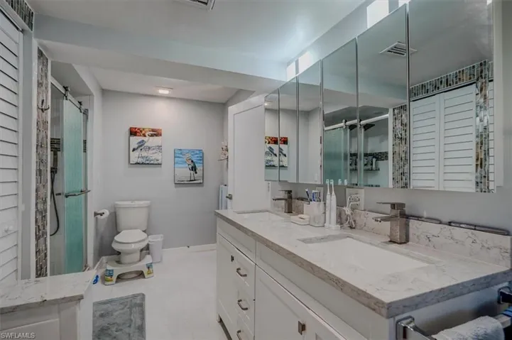 Bathroom with vanity, an enclosed shower, and toilet