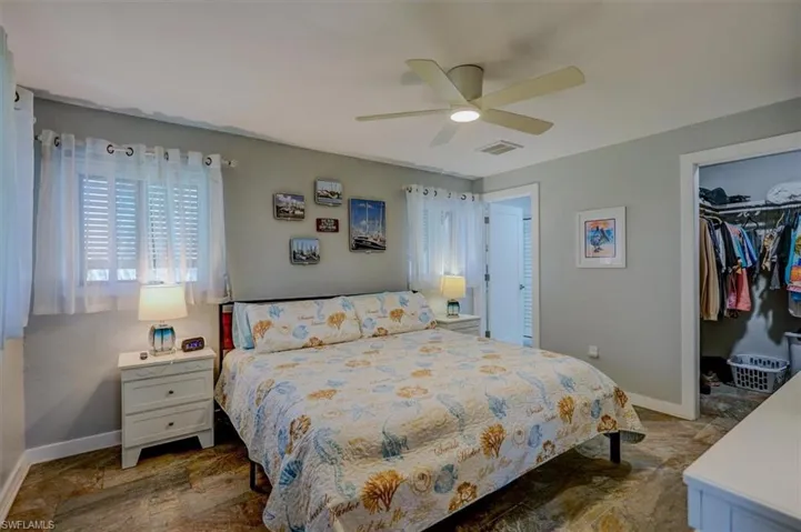 Bedroom with a spacious closet, ceiling fan, and a closet