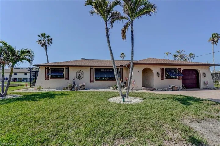 Ranch-style house with a garage and a front lawn