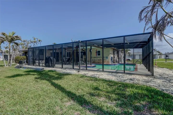 Back of property featuring a patio, a lanai, and a lawn