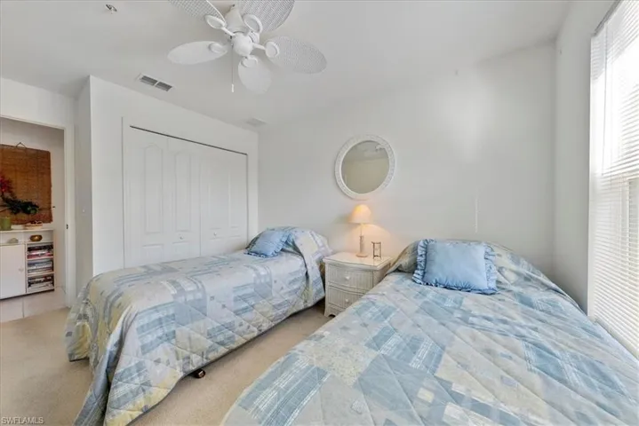 Bedroom with carpet floors, a closet, visible vents, and a ceiling fan