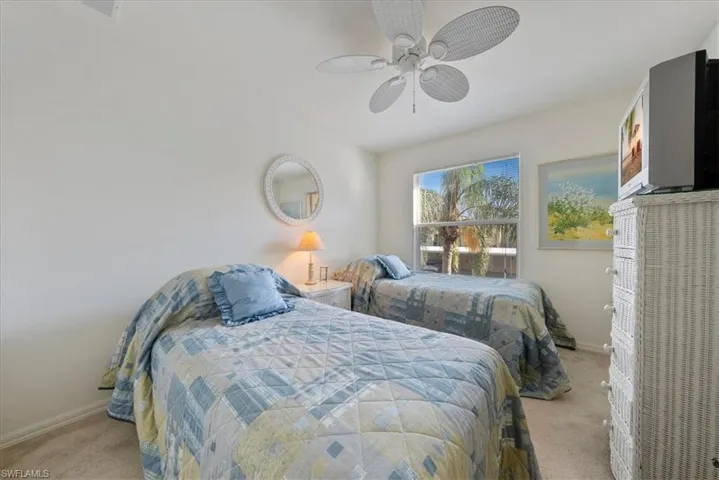 Bedroom with carpet, baseboards, and a ceiling fan