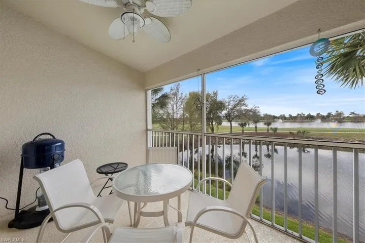 Sunroom featuring a water view and a ceiling fan