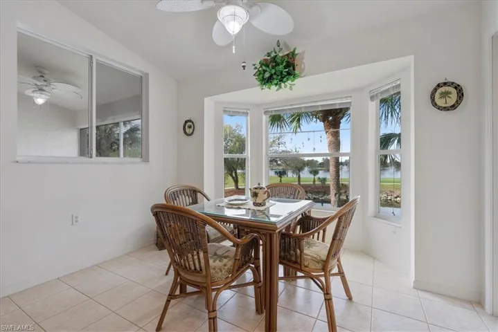 Dining space with ceiling fan, baseboards, and light tile patterned flooring
