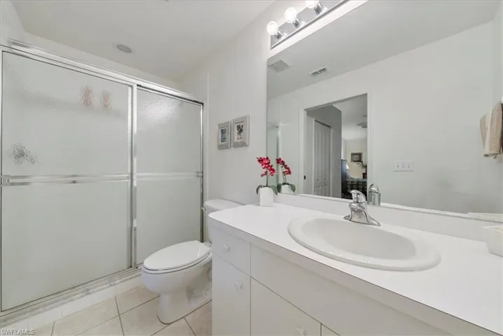 Bathroom featuring toilet, a stall shower, visible vents, and vanity