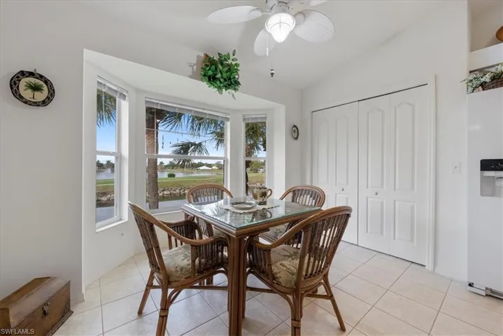 Dining area with ceiling fan, vaulted ceiling, and light tile patterned floors