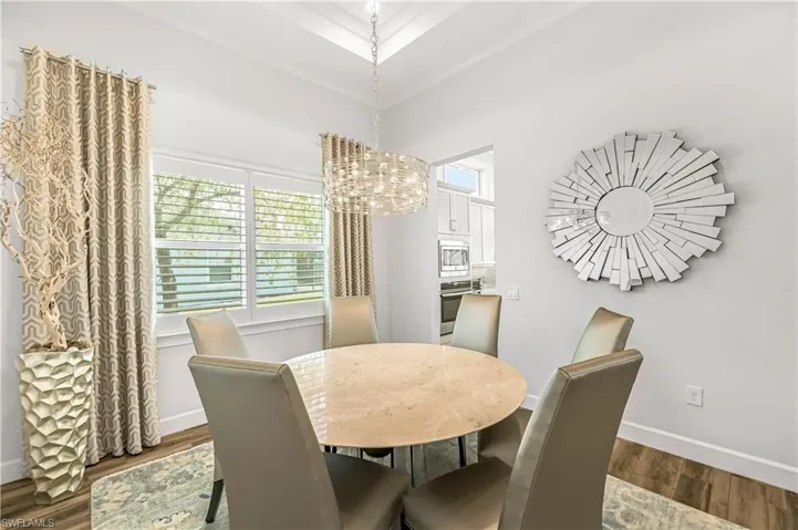 Dining room featuring dark wood-style flooring and a chandelier