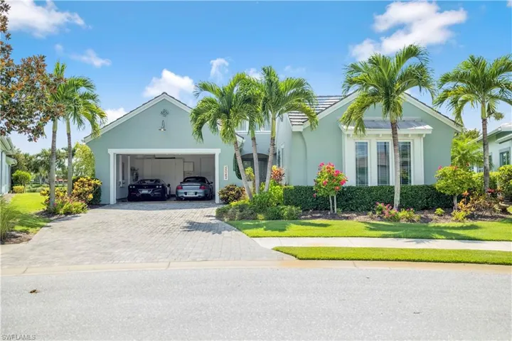 View of front facade with decorative driveway, a garage, stucco siding, and a front lawn