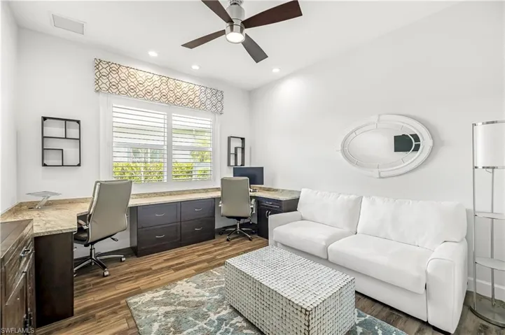 Home office with dark wood-style floors, ceiling fan, recessed lighting, and built in study area