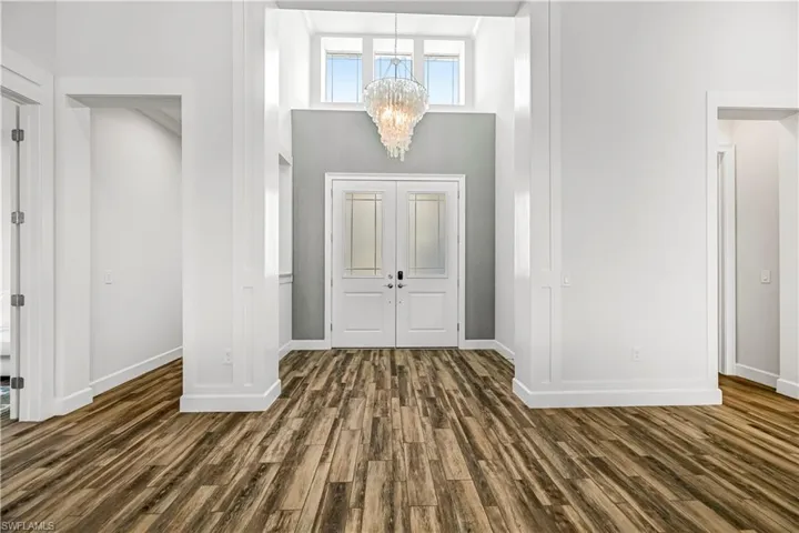 Entryway with a chandelier, dark wood-style floors, and a high ceiling