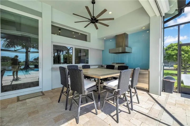 Dining space featuring stone tile floors, a ceiling fan, recessed lighting, and a towering ceiling