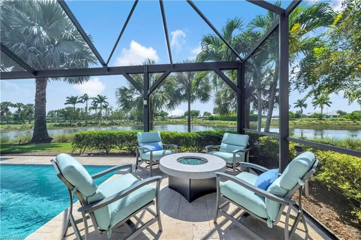 View of patio / terrace featuring an outdoor fire pit, a water view, a lanai, and an outdoor pool