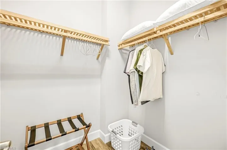 Walk in closet with wood finished floors