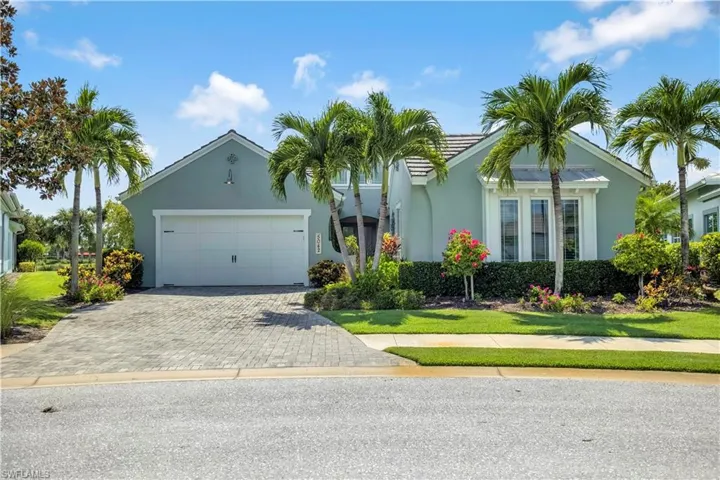 View of front of house with decorative driveway, stucco siding, and an attached garage