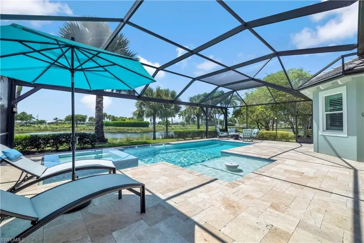 View of pool featuring a pool with connected hot tub, a sunroom, a patio, and a lanai