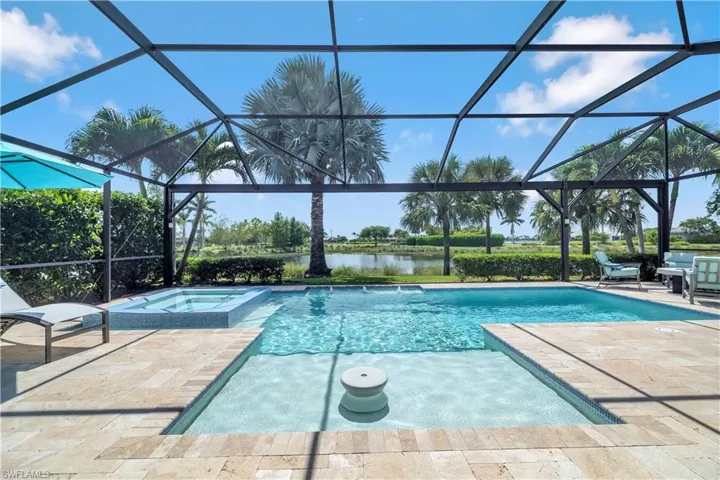 View of swimming pool with a sunroom, a patio, a pool with connected hot tub, and a water view