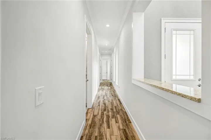 Hall featuring dark wood finished floors and recessed lighting