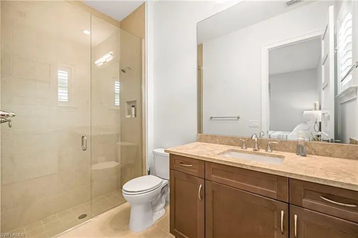 Bathroom featuring ensuite bathroom, a shower stall, vanity, and light tile patterned floors