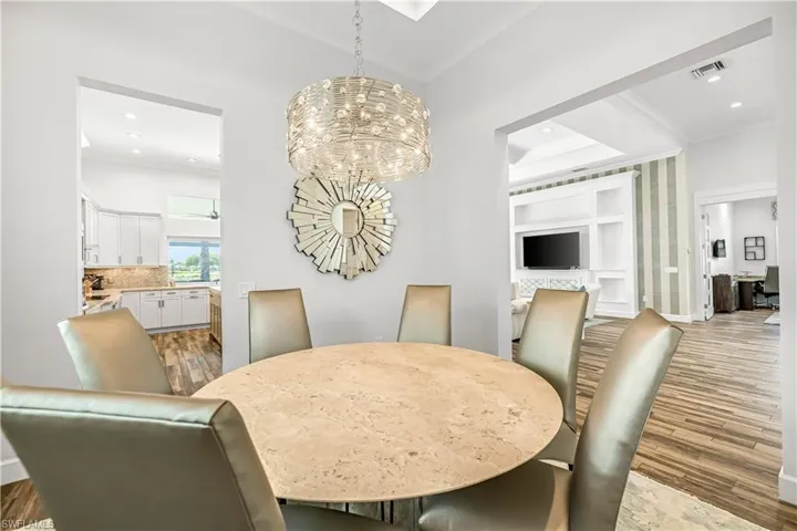 Dining space featuring wood finished floors, crown molding, a chandelier, recessed lighting, and an office area