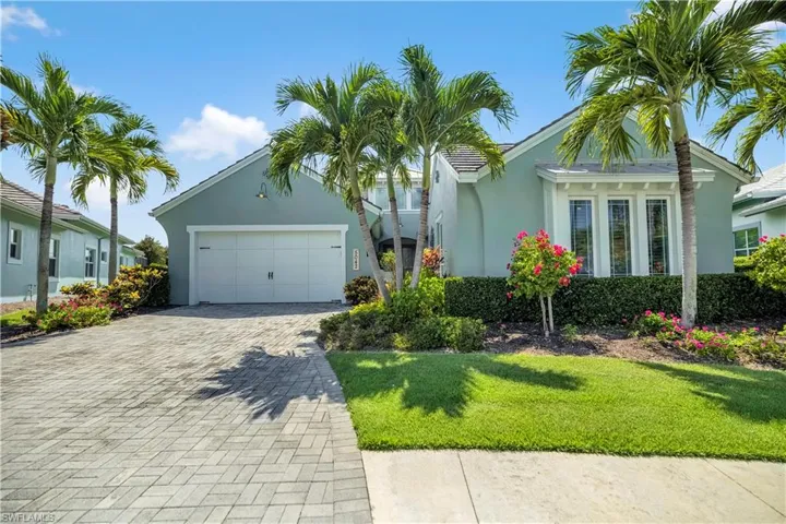 Ranch-style home featuring decorative driveway, stucco siding, a garage, and a front lawn