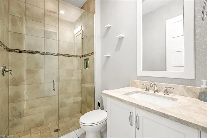 Full bath with a stall shower, vanity, and tile patterned flooring