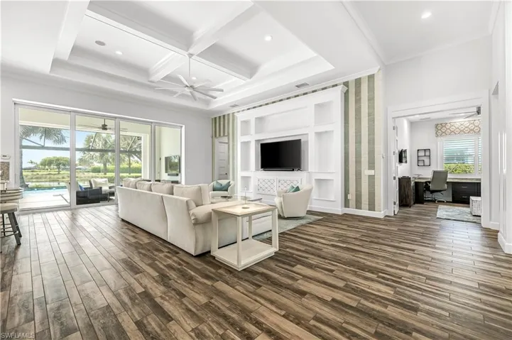 Living area featuring dark wood-style flooring, recessed lighting, ceiling fan, built in desk, and beamed ceiling