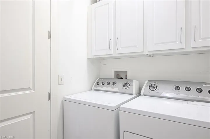 Laundry room with washer and clothes dryer and cabinets