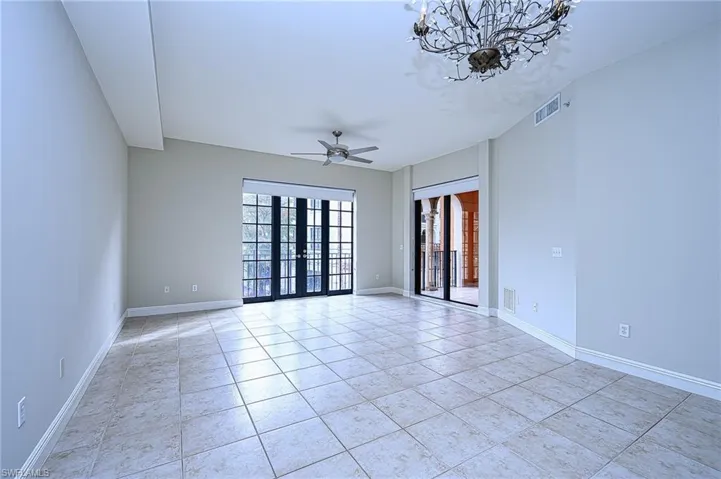 Spare room featuring ceiling fan, french doors, and light tile patterned flooring