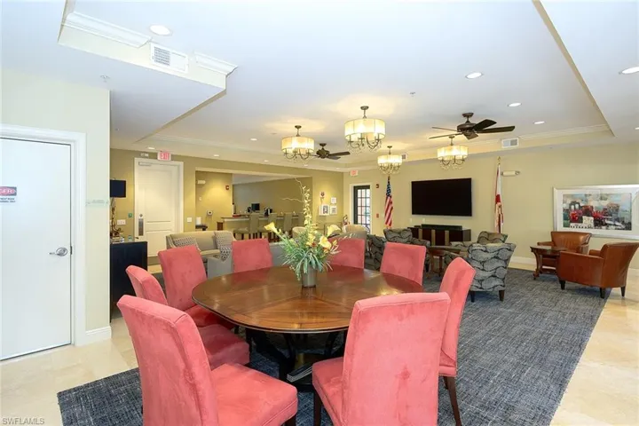 Dining room with ceiling fan with notable chandelier and a tray ceiling