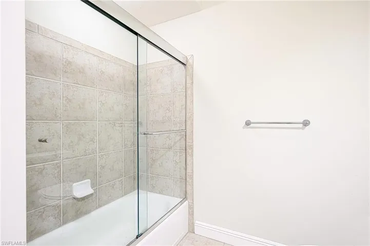 Bathroom featuring bath / shower combo with glass door