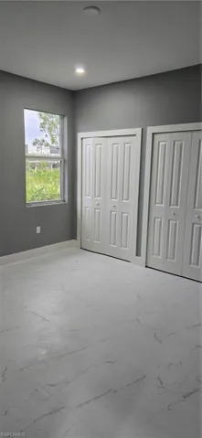 Unfurnished bedroom featuring multiple closets, recessed lighting, and baseboards