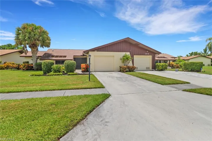 Single story home with a garage and a front lawn
