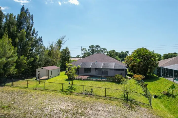 Back of structure, featuring fence and shed