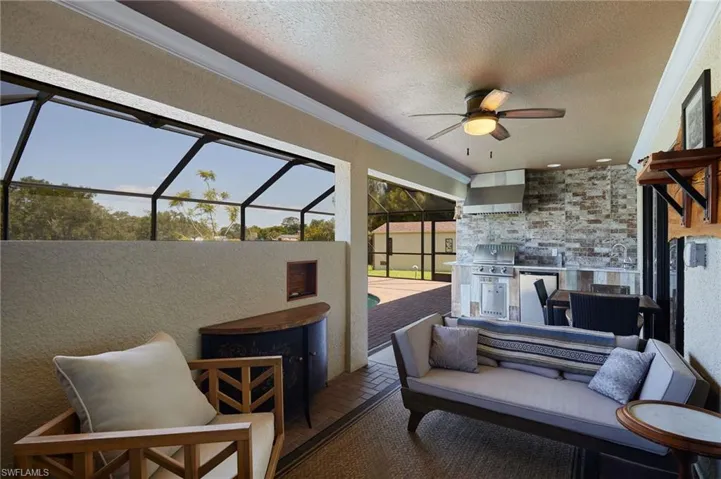 View of patio featuring grilling area, ceiling fan, a lanai, and an outdoor hangout area