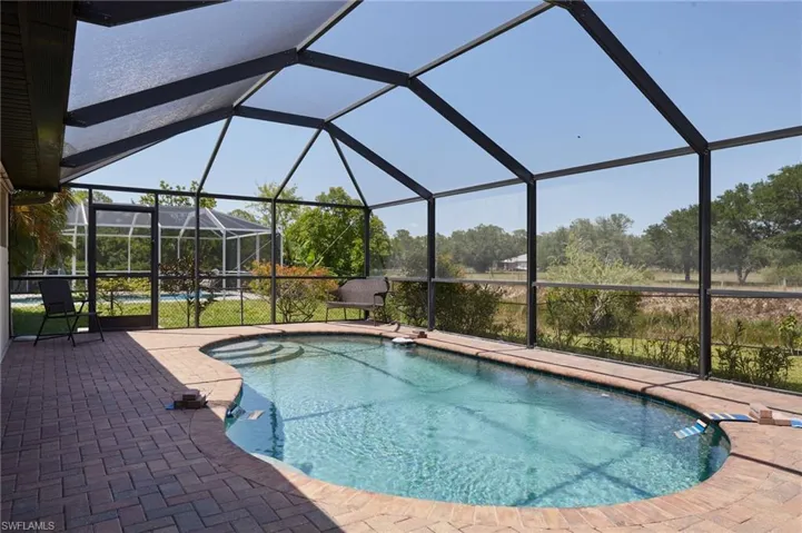Outdoor pool featuring a patio and screen enclosure