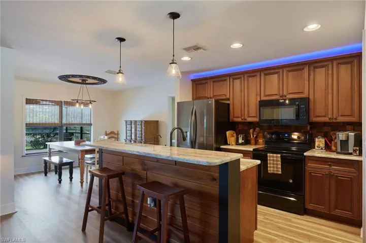 Kitchen with cabinets, tongue-and-groove island, and teak backsplash