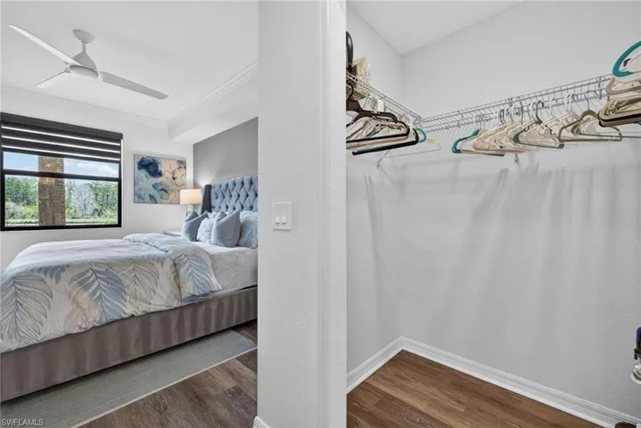 Bedroom featuring wood-finish flooring, a contemporary ceiling fan, and crown molding