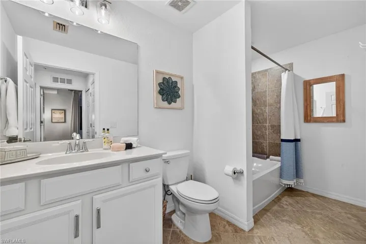Bathroom featuring a white vanity with an integrated sink, polished chrome faucet, and overhead lighting