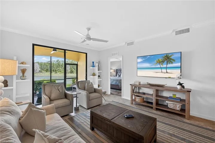 Living area featuring a spacious screened-in patio overlooking a body of water and natural landscape